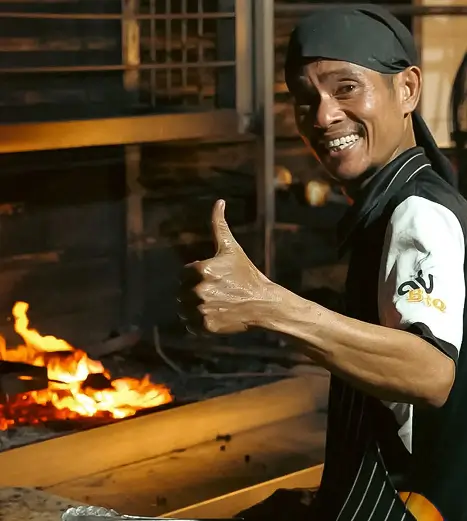 Ali at the charcoal grill, flames up